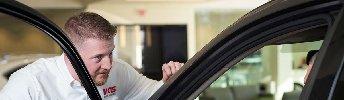 MAS employee looking at a car