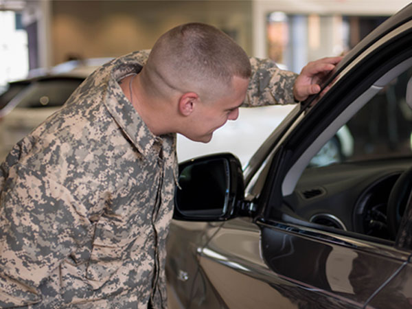 A soldier looking at a car